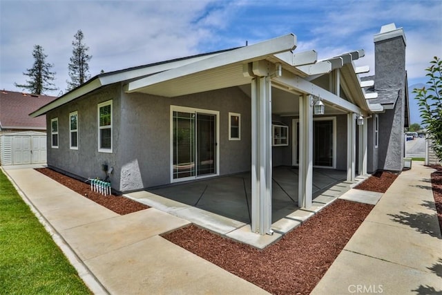 10249 Candlewood St, Rancho Cucamonga, CA 91730 - back of property with stucco siding, a patio area, and a chimney