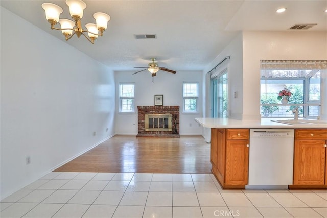 10249 Candlewood St, Rancho Cucamonga, CA 91730 - kitchen with dishwasher, a brick fireplace, light countertops, a ceiling fan, and brown cabinets