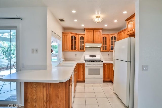 10249 Candlewood St, Rancho Cucamonga, CA 91730 - kitchen with white appliances, a peninsula, a sink, under cabinet range hood, and brown cabinets