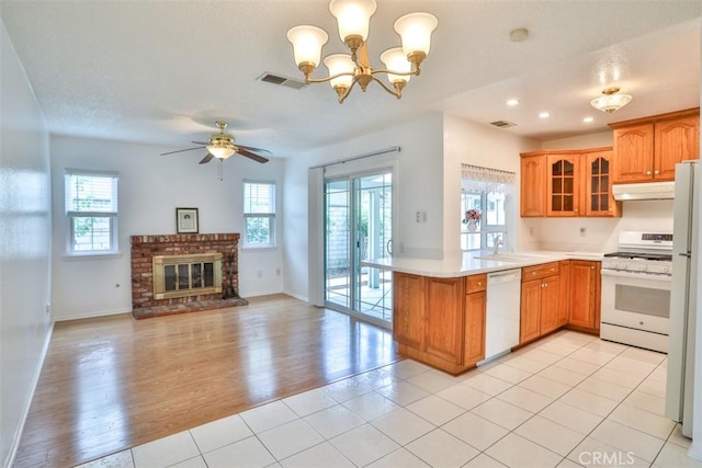 10249 Candlewood St, Rancho Cucamonga, CA 91730 - kitchen with white appliances, under cabinet range hood, a peninsula, glass insert cabinets, and open floor plan