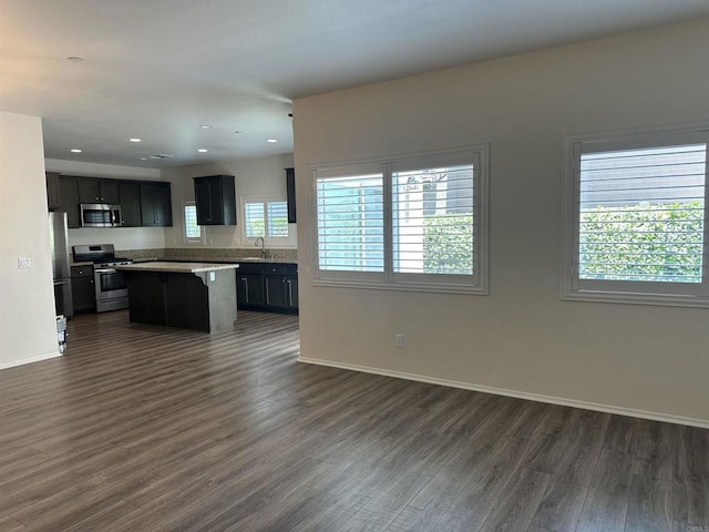 253 Oberland Way, Fallbrook, CA 92028 - kitchen with stainless steel appliances, open floor plan, dark wood finished floors, a sink, and a kitchen island