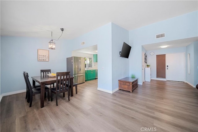 6597 Kinlock Ave, Rancho Cucamonga, CA 91737 - dining room featuring light wood finished floors, a chandelier, and baseboards