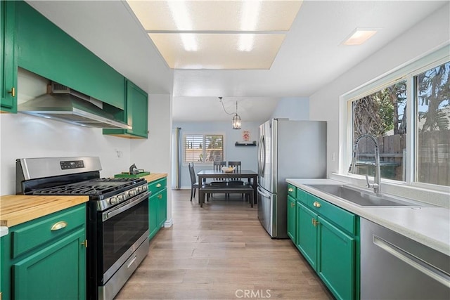 6597 Kinlock Ave, Rancho Cucamonga, CA 91737 - kitchen with stainless steel appliances, wall chimney exhaust hood, a sink, light wood-type flooring, and green cabinetry