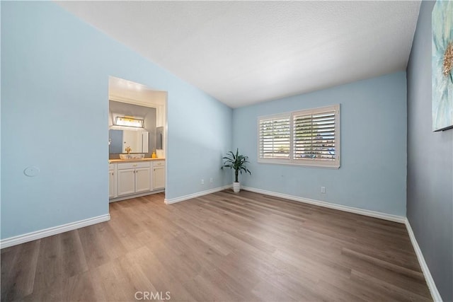6597 Kinlock Ave, Rancho Cucamonga, CA 91737 - spare room featuring light wood finished floors, baseboards, and vaulted ceiling