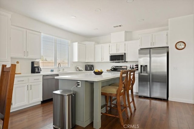 1467 Hunter Moon Way, Beaumont, CA 92223 - kitchen featuring stainless steel appliances, white cabinets, a kitchen island, and dark wood finished floors
