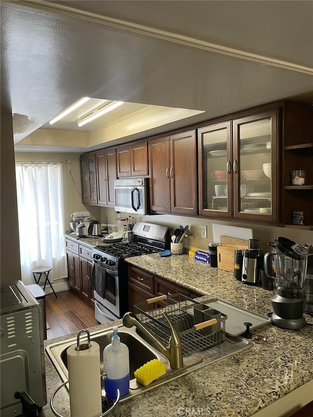 404 Brighton Spgs, Costa Mesa, CA 92627 - kitchen with appliances with stainless steel finishes, dark wood-style floors, glass insert cabinets, and dark brown cabinets