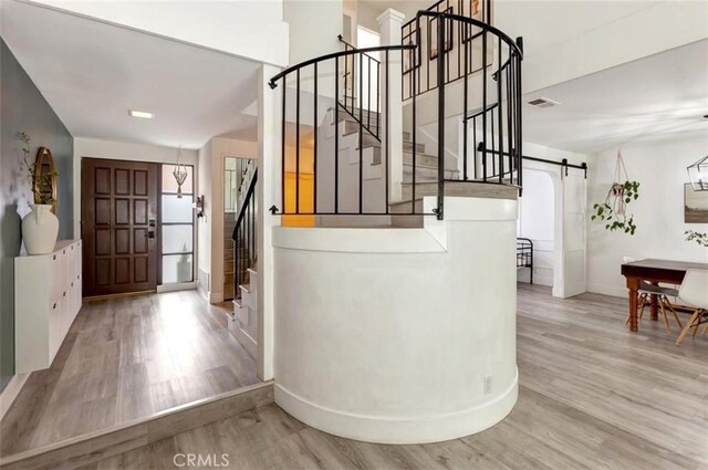 32457 Spyglass Ct, San Juan Capistrano, CA 92675 - foyer featuring a barn door, stairway, wood finished floors, and baseboards