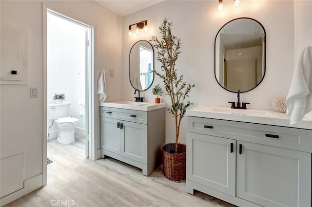 32457 Spyglass Ct, San Juan Capistrano, CA 92675 - bathroom featuring wood finished floors, two vanities, and toilet