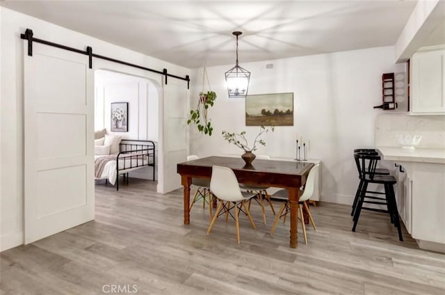 32457 Spyglass Ct, San Juan Capistrano, CA 92675 - dining room featuring a barn door, light wood-type flooring, and baseboards