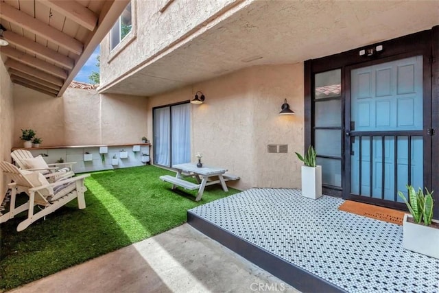 32457 Spyglass Ct, San Juan Capistrano, CA 92675 - view of exterior entry with stucco siding, a patio, and a yard