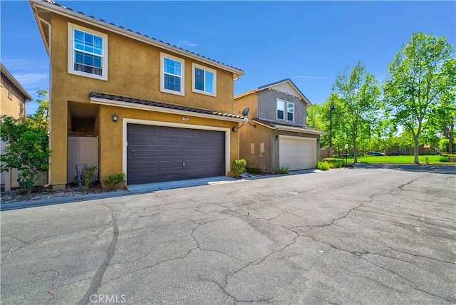 7042 Logsdon Dr, Eastvale, CA 92880 - view of front of house with stucco siding, an attached garage, and driveway