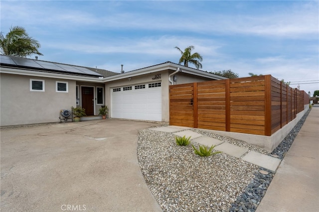 6017 Carnegie St, San Diego, CA 92122 - view of front facade featuring stucco siding, concrete driveway, roof mounted solar panels, and an attached garage