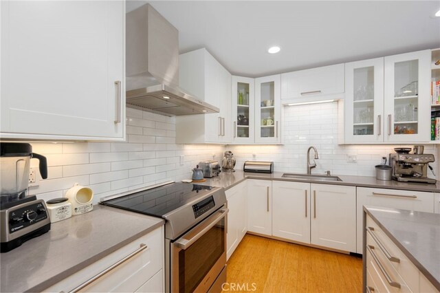 6017 Carnegie St, San Diego, CA 92122 - kitchen with stainless steel electric range oven, a sink, wall chimney range hood, white cabinets, and recessed lighting