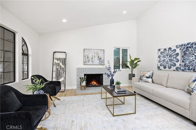 1348 Sandia St, Corona, CA 92882 - living area with wood finished floors, a brick fireplace, lofted ceiling, recessed lighting, and baseboards