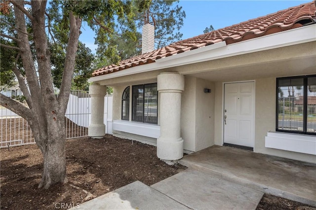 1348 Sandia St, Corona, CA 92882 - doorway to property with stucco siding, a chimney, and a tiled roof