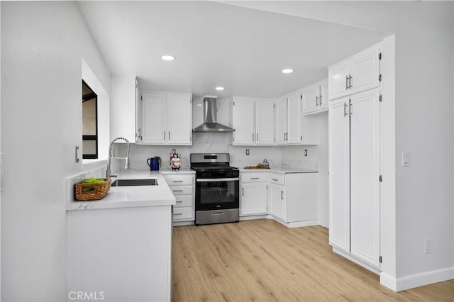 1348 Sandia St, Corona, CA 92882 - kitchen featuring wall chimney range hood, a sink, stainless steel gas stove, light wood-type flooring, and white cabinetry
