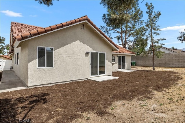 1348 Sandia St, Corona, CA 92882 - back of property featuring a fenced backyard, stucco siding, and a tiled roof