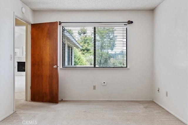 645 Worcester Dr, Cambria, CA 93428 - empty room featuring healthy amount of natural light, light colored carpet, a fireplace, and a textured ceiling
