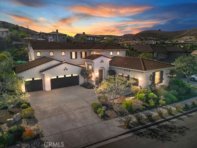29310 Paseo Palmar, San Juan Capistrano, CA 92675 - mediterranean / spanish house with an attached garage, a tile roof, driveway, stucco siding, and a residential view