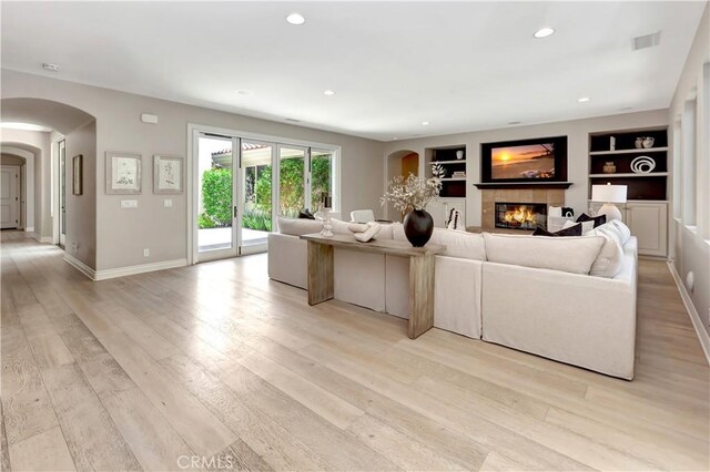 29310 Paseo Palmar, San Juan Capistrano, CA 92675 - living area with arched walkways, a tiled fireplace, light wood-style flooring, baseboards, and recessed lighting