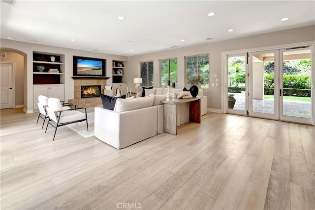 29310 Paseo Palmar, San Juan Capistrano, CA 92675 - living area featuring built in features, a warm lit fireplace, arched walkways, light wood-type flooring, and recessed lighting