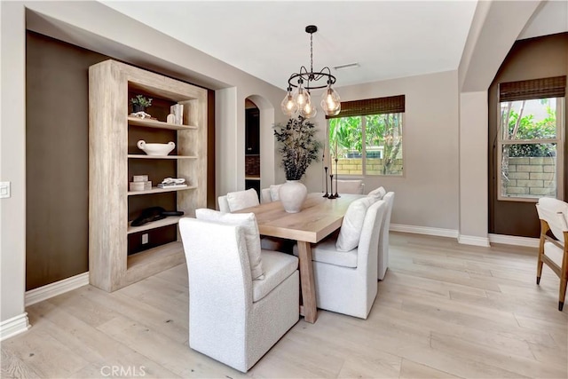 29310 Paseo Palmar, San Juan Capistrano, CA 92675 - dining area featuring arched walkways, light wood-type flooring, and a chandelier
