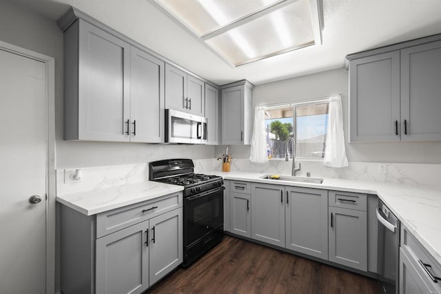 22432245 S Lanoitan, National City, CA 91950 - kitchen featuring appliances with stainless steel finishes, a sink, gray cabinets, dark wood finished floors, and light stone counters