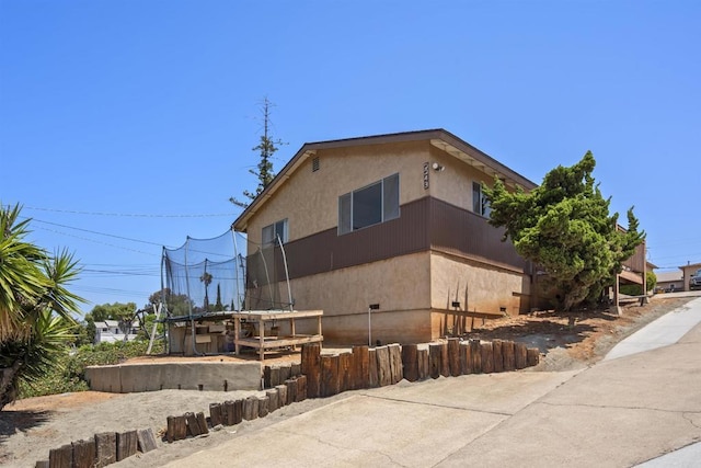 22432245 S Lanoitan, National City, CA 91950 - view of side of property with stucco siding and a trampoline