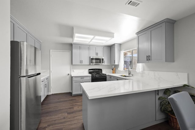 22432245 S Lanoitan, National City, CA 91950 - kitchen featuring stainless steel appliances, a sink, a peninsula, gray cabinets, and dark wood-style floors