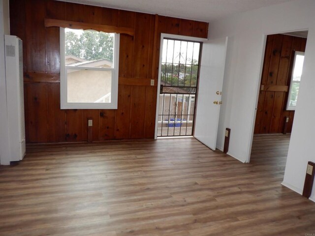 22432245 S Lanoitan, National City, CA 91950 - spare room with wood finished floors, healthy amount of natural light, a heating unit, baseboards, and wooden walls