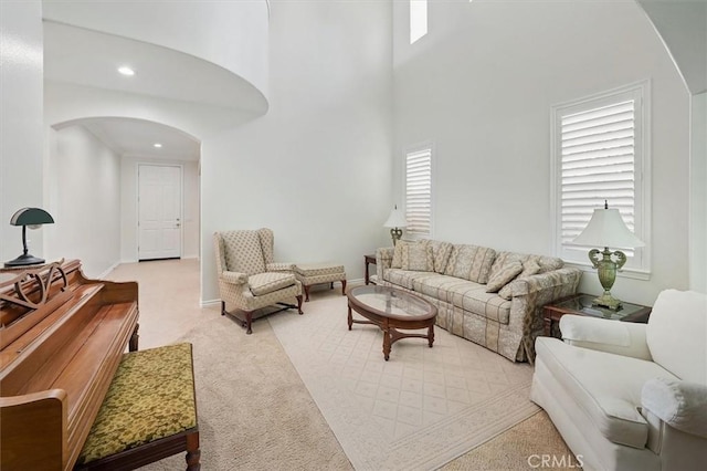 19728 Ellis Henry Ct, Newhall, CA 91321 - living room featuring arched walkways, plenty of natural light, light colored carpet, a towering ceiling, and recessed lighting