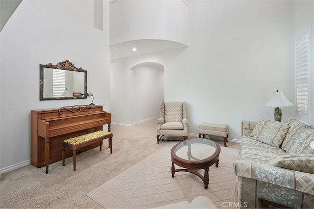 19728 Ellis Henry Ct, Newhall, CA 91321 - living room with carpet floors, arched walkways, baseboards, and a high ceiling