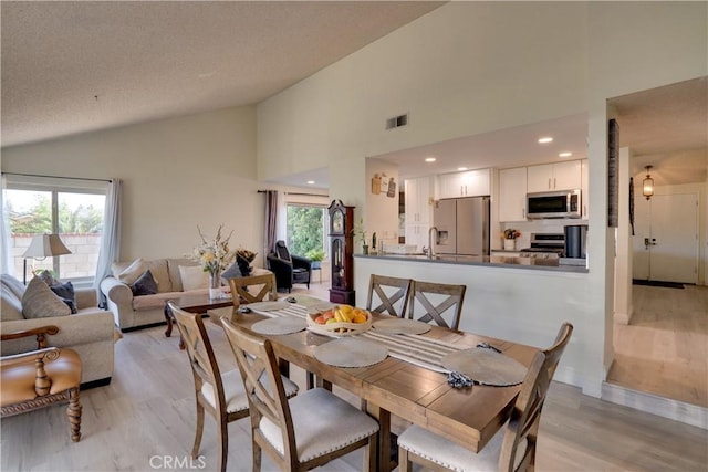 12076 Racket Ct, Moreno Valley, CA 92557 - dining room with light wood-type flooring and high vaulted ceiling