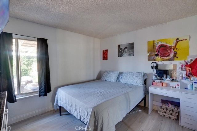 12076 Racket Ct, Moreno Valley, CA 92557 - bedroom featuring a textured ceiling, multiple windows, light wood-style flooring, and baseboards