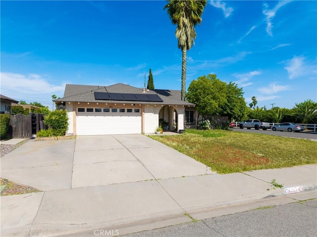 12076 Racket Ct, Moreno Valley, CA 92557 - view of front of house featuring stucco siding, driveway, roof mounted solar panels, and an attached garage