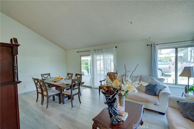 12076 Racket Ct, Moreno Valley, CA 92557 - dining space with healthy amount of natural light, light wood-style floors, a textured ceiling, and lofted ceiling