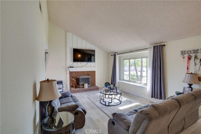 12076 Racket Ct, Moreno Valley, CA 92557 - living room with wood finished floors, a textured ceiling, vaulted ceiling, and a brick fireplace