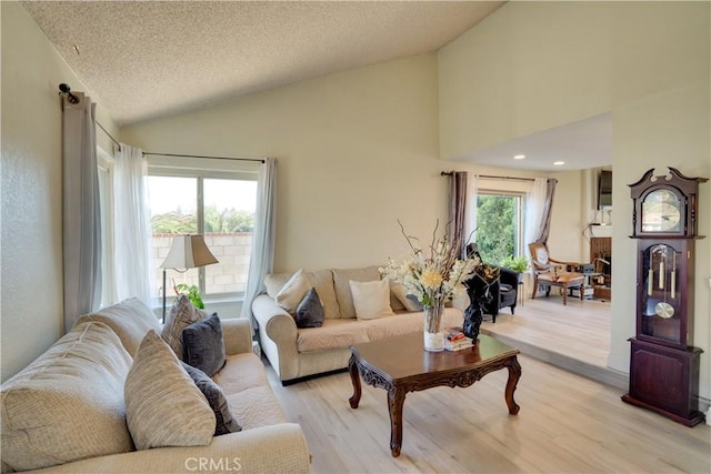 12076 Racket Ct, Moreno Valley, CA 92557 - living area with lofted ceiling, light wood-type flooring, and a textured ceiling