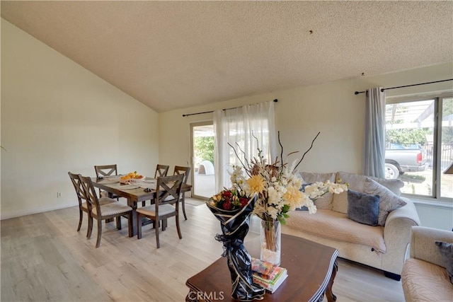12076 Racket Ct, Moreno Valley, CA 92557 - dining space with light wood finished floors, lofted ceiling, and a textured ceiling