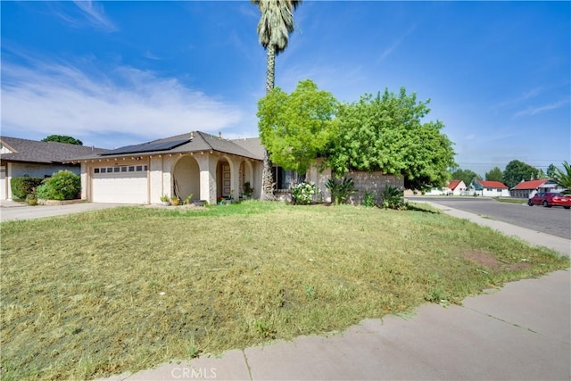 12076 Racket Ct, Moreno Valley, CA 92557 - ranch-style home with solar panels, a front lawn, an attached garage, stucco siding, and concrete driveway
