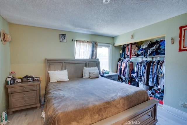 12076 Racket Ct, Moreno Valley, CA 92557 - bedroom with a textured ceiling, light wood-style floors, baseboards, and a closet