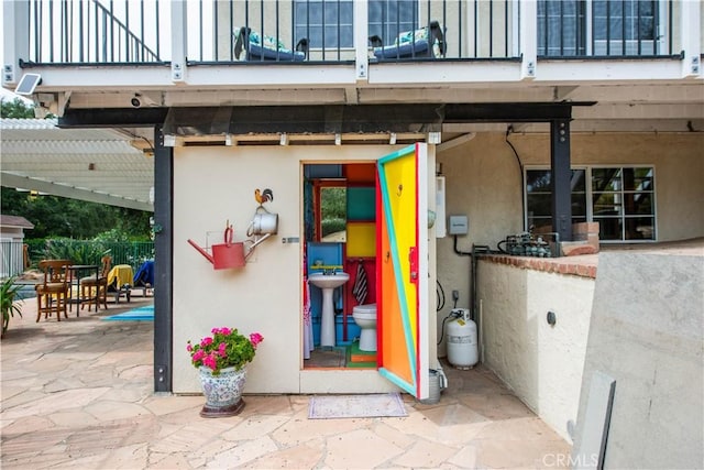 23328 Valley Circle Blvd, Chatsworth, CA 91311 - view of exterior entry featuring a balcony, stucco siding, and a patio area