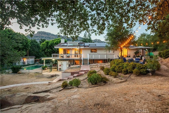 23328 Valley Circle Blvd, Chatsworth, CA 91311 - back of property with roof mounted solar panels, a deck with mountain view, a patio, a chimney, and an outdoor pool