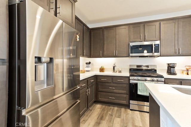 10550 Wilding Dr, Rancho Cucamonga, CA 91730 - kitchen with stainless steel appliances, dark brown cabinetry, light wood-style floors, and light countertops