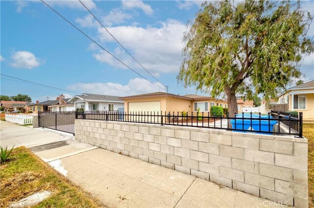 1442 W 220th St, Torrance, CA 90501 - view of side of property featuring a fenced front yard, an attached garage, concrete driveway, a residential view, and stucco siding