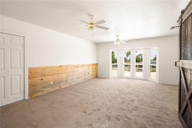 16481 Valle Vista Way, Riverside, CA 92506 - carpeted empty room featuring a barn door, a ceiling fan, and wooden walls