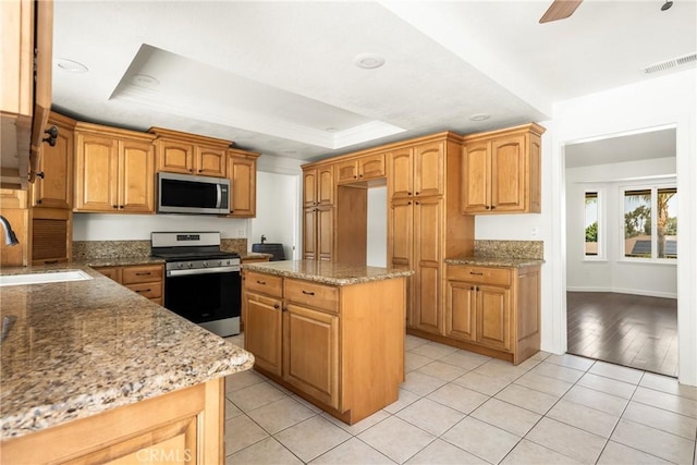 16481 Valle Vista Way, Riverside, CA 92506 - kitchen with appliances with stainless steel finishes, a raised ceiling, a sink, light stone counters, and recessed lighting