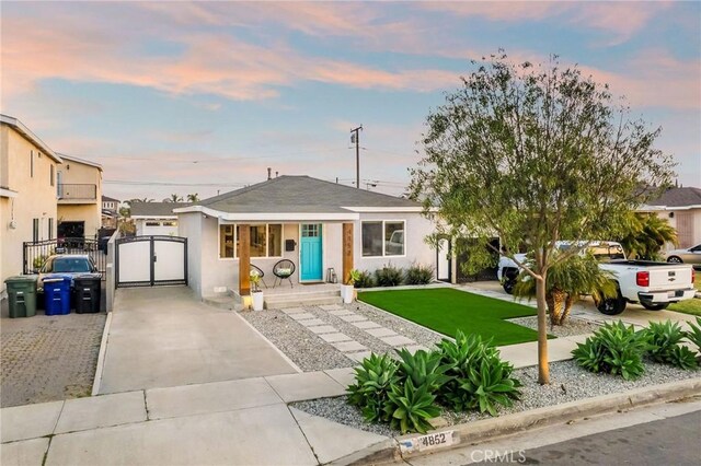 4852 W 129th St, Hawthorne, CA 90250 - view of front of home with a gate, driveway, and stucco siding