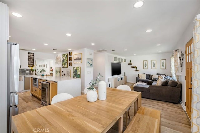 4852 W 129th St, Hawthorne, CA 90250 - dining space with beverage cooler, light wood-style floors, recessed lighting, and a barn door