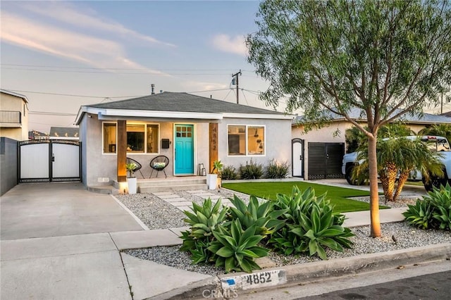 4852 W 129th St, Hawthorne, CA 90250 - bungalow-style house featuring a gate, stucco siding, covered porch, and roof with shingles